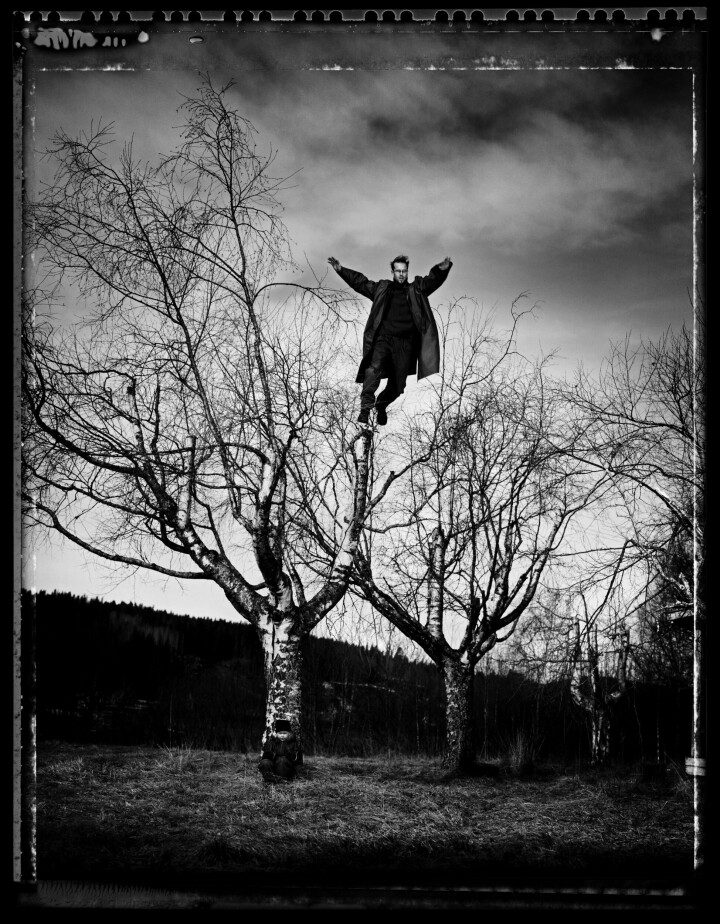 Självporträtt från 2004 där Thron hoppar från en björk. Dottern Celina smög sig också in i bilden. Foto: Thron Ullberg