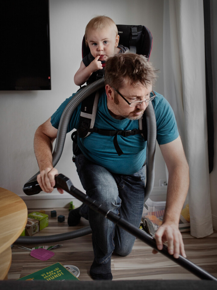 Eftersom sonen Gustav precis har börjat lära sig att gå, sätter pappan Ola Larsson honom i en sele när det är dags att städa. Att fånga vardagliga situationer har varit viktigt för Johan när han fotograferat.